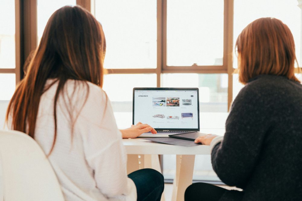 Two women behind a computer